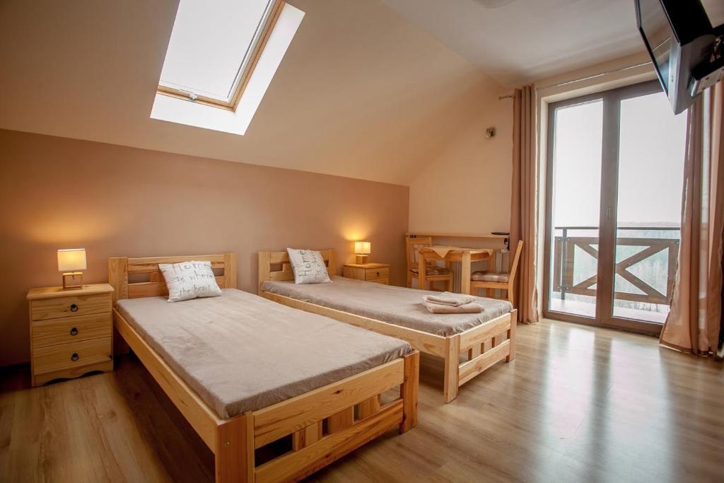 1 dormitorio con 2 camas individuales y tragaluz en Pokoje Siódme Niebo en Szklarska Poręba