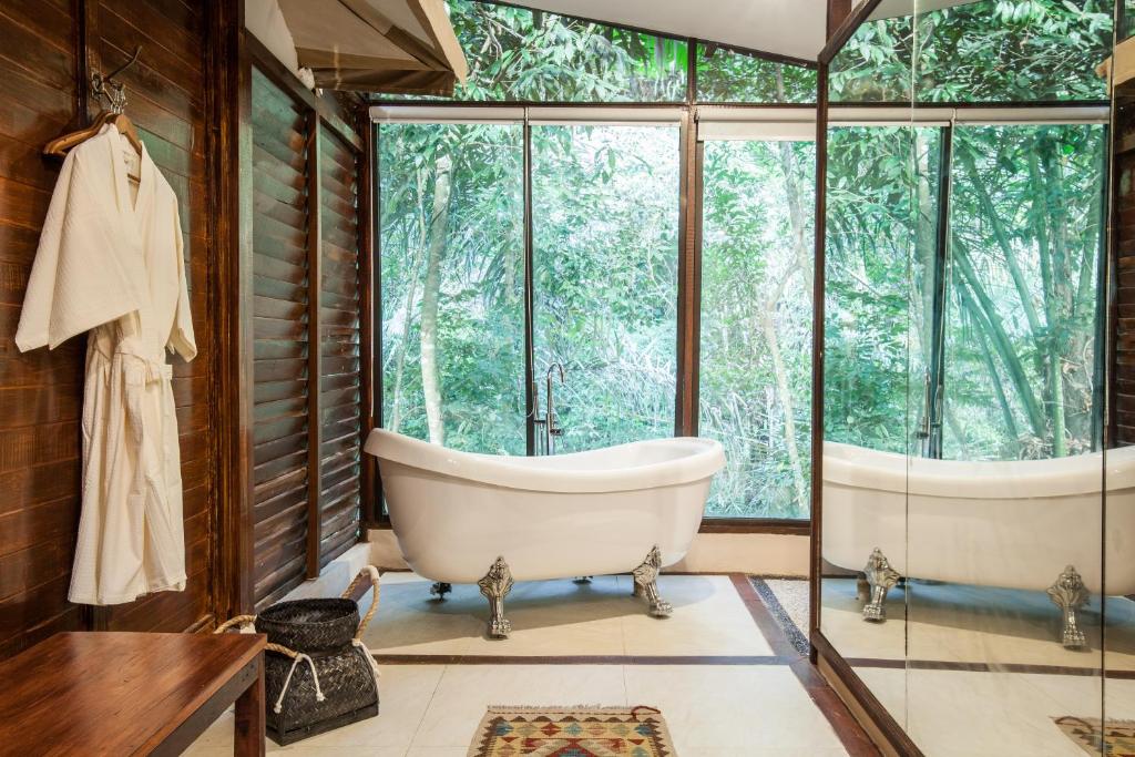 a bathroom with a tub and a large window at Galalima Glamping in Meliling