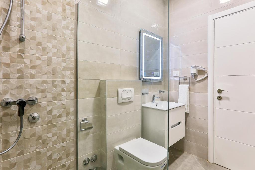 a bathroom with a toilet and a sink and a shower at Apolon Apart in Bar, Susanj