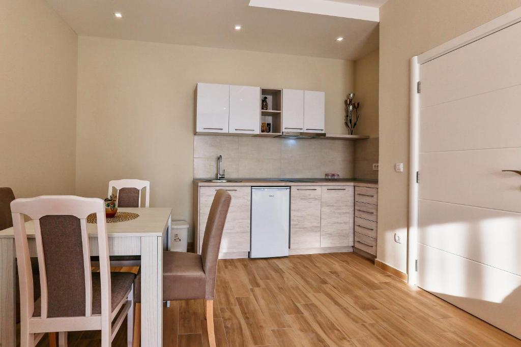 a small kitchen with a table and a refrigerator at Apolon Apart in Bar, Susanj