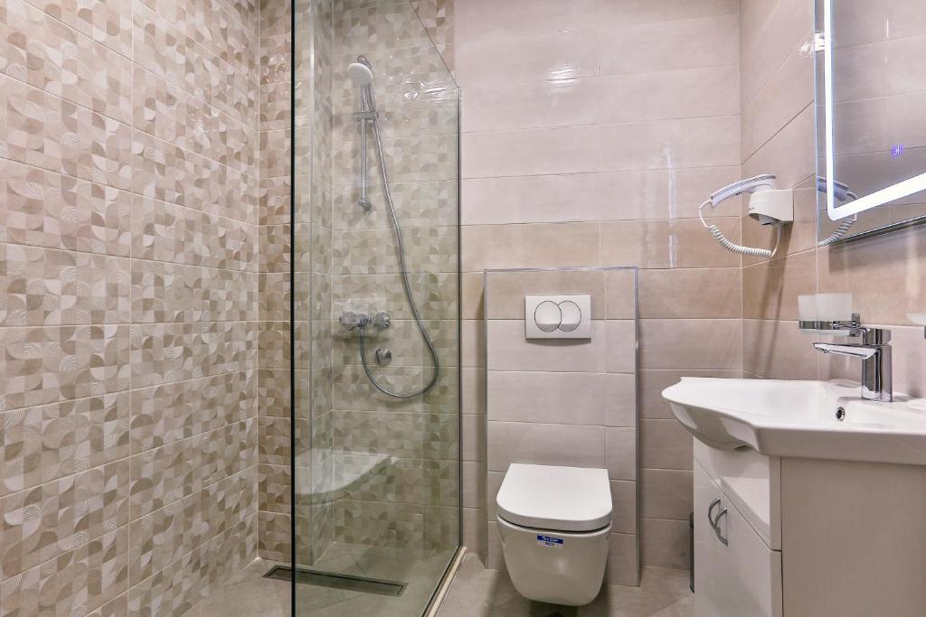 a bathroom with a shower and a toilet and a sink at Apolon Apart in Bar, Susanj