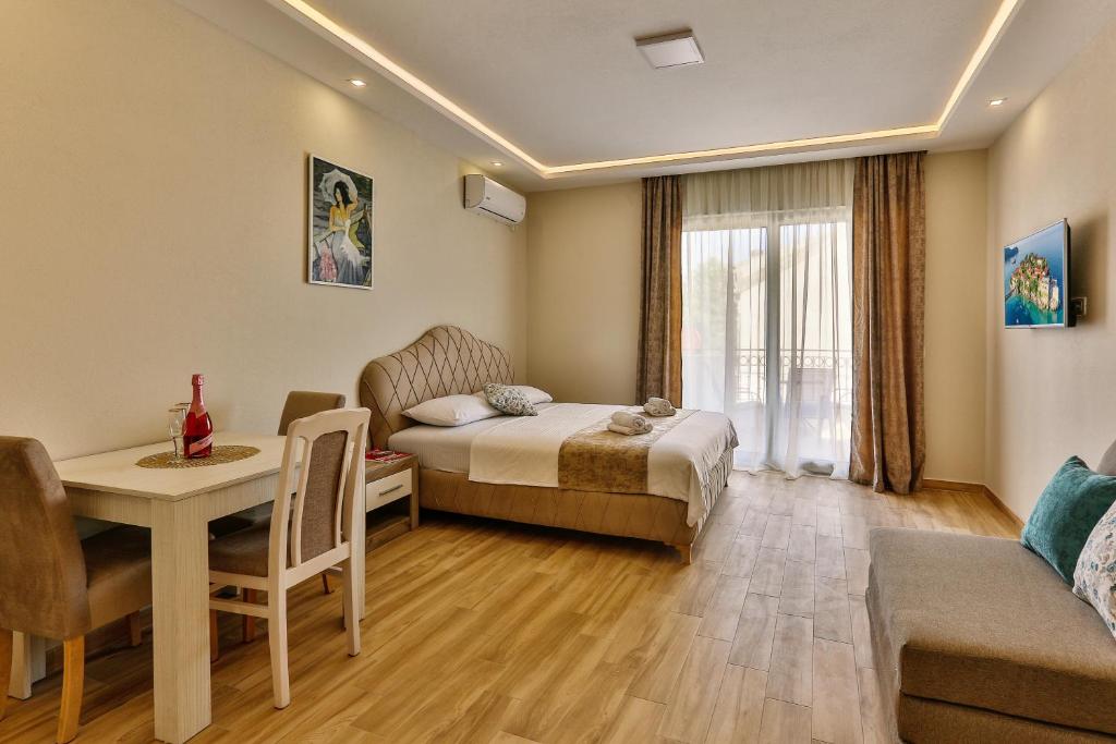 a hotel room with a bed and a table and a dining room at Apolon Apart in Bar, Susanj