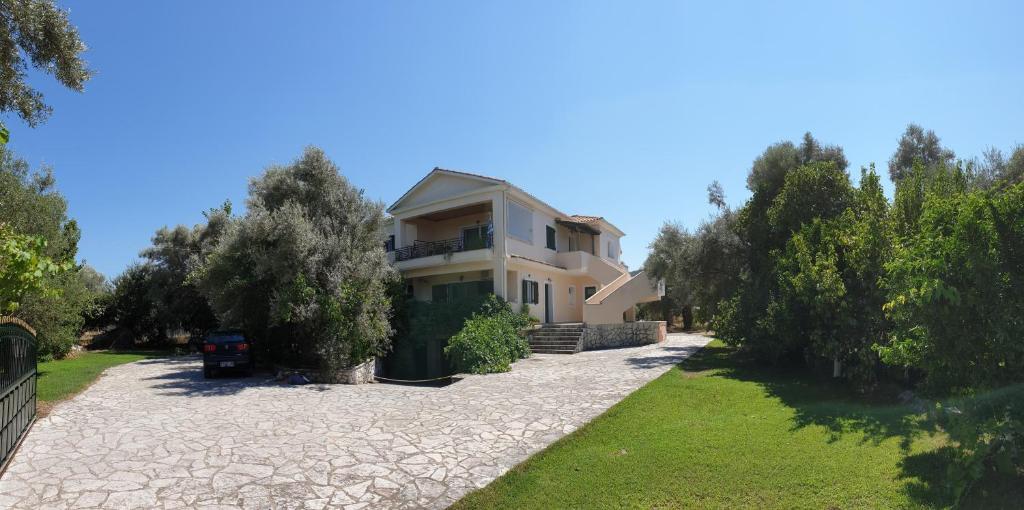 a villa with a driveway in front of a house at Angela apartments in Lefkada Town