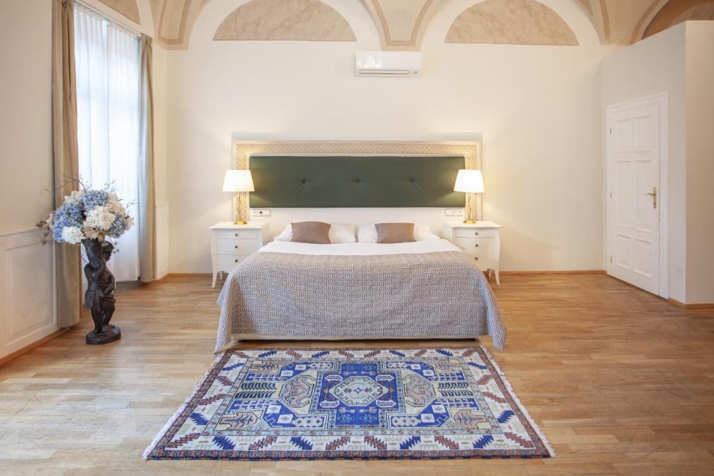 ein Schlafzimmer mit einem Bett und einem Teppich auf dem Boden in der Unterkunft Little King U Malvaze in Prag
