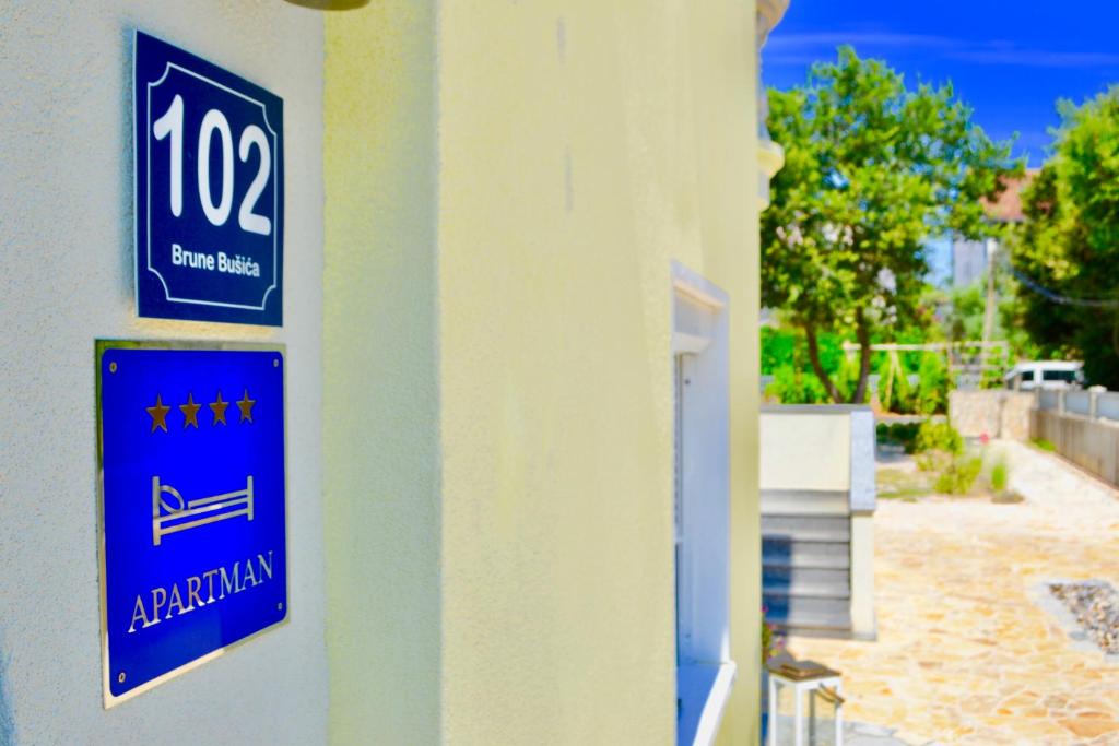 a blue sign on the side of a building at Apartmani Pax in Pakoštane