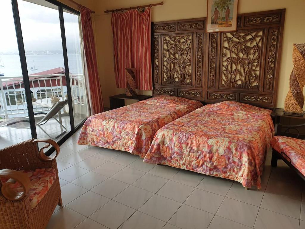 ein Hotelzimmer mit 2 Betten und einem Balkon in der Unterkunft Agréable Studio vue mer au Trois Îlets in Les Trois-Îlets