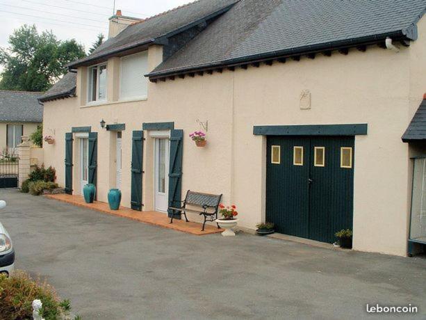 a house with a green door and a bench at chambres d'hotes REGINE in La Gouesnière