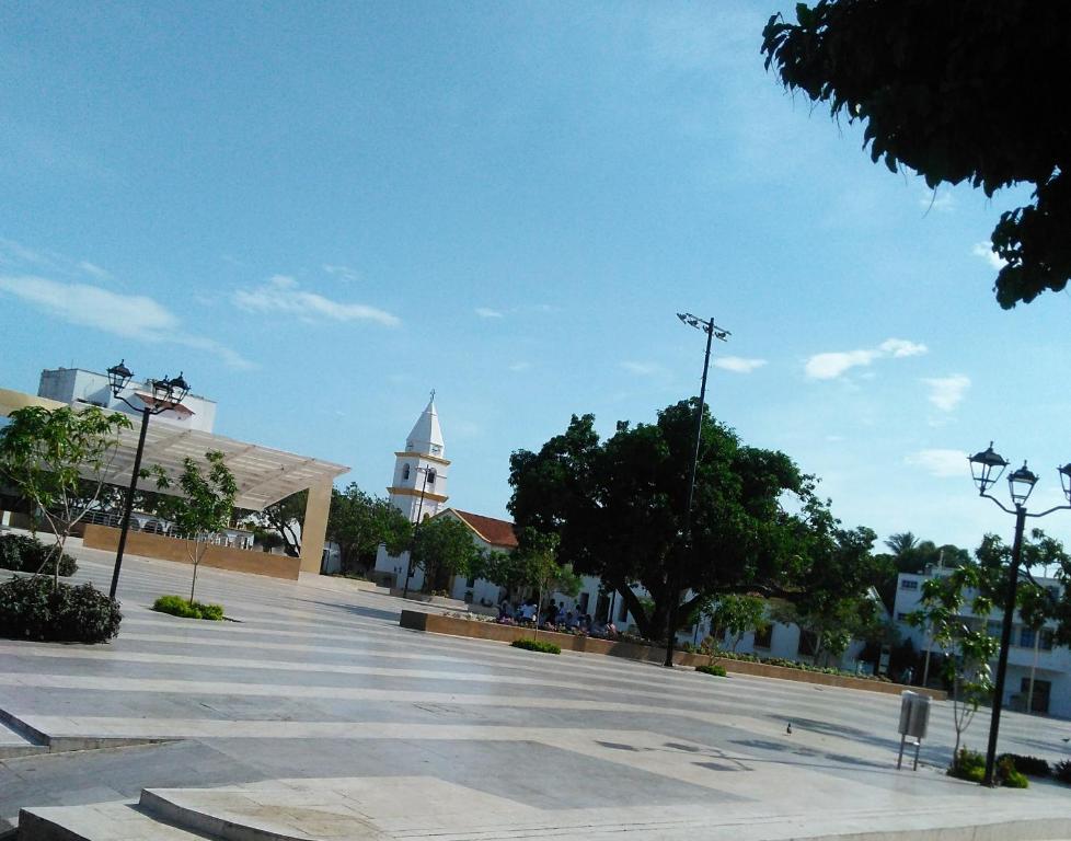 a large parking lot with a building with a clock tower at Hotel Kasvel in Valledupar