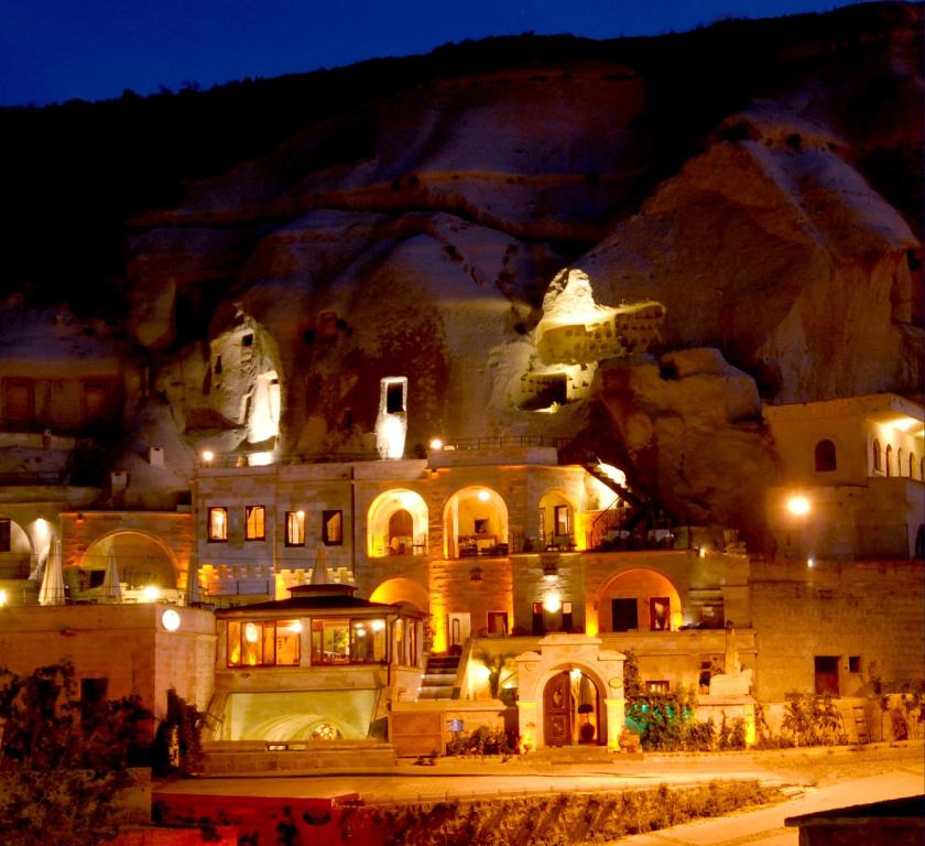 um edifício é iluminado à noite em frente a uma montanha em Miras Hotel em Goreme