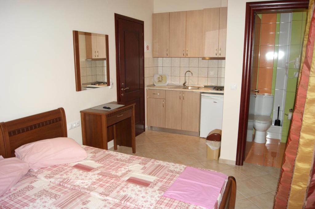 1 dormitorio pequeño con 1 cama y cocina en Marie Claire Studios, en Olympiakí Aktí