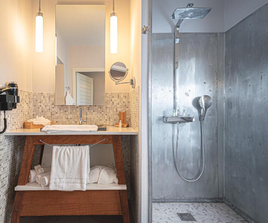 un bagno con doccia e lavandino di French Coco a La Trinité