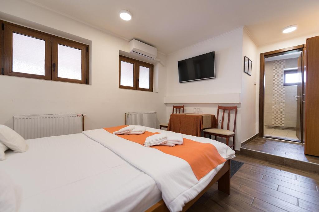 1 dormitorio con 1 cama grande y TV en Rooms Gat en Subotica