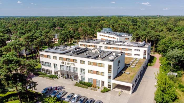 una vista aérea de un gran edificio blanco con coches aparcados en Z-Hotel Business & Spa, en Otwock