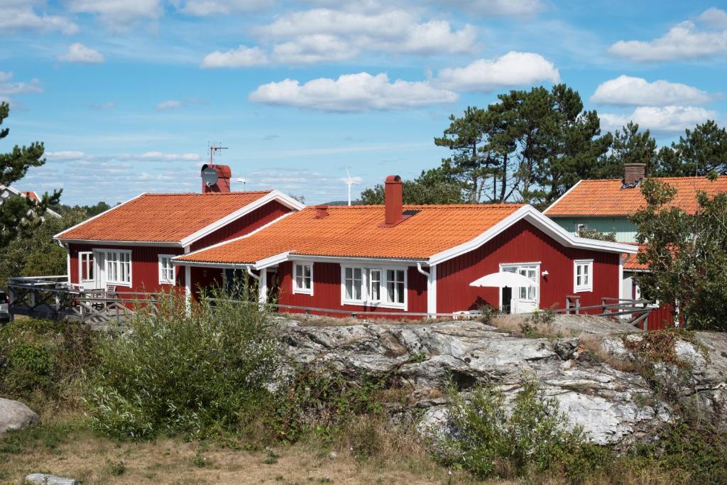 une maison rouge avec un toit orange dans l'établissement Kvarnstugan, à Mollösund