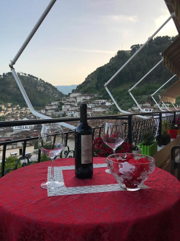 a bottle of wine sitting on a table with wine glasses at Rezidenca Aurel in Berat