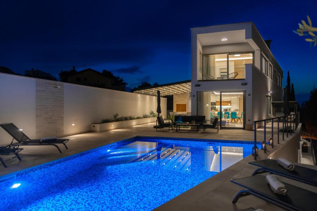 Villa con piscina por la noche en Villa Bondi, en Supetar