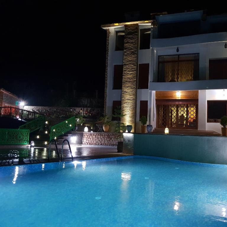 a swimming pool in front of a building at night at Dar Zayane in Khenifra