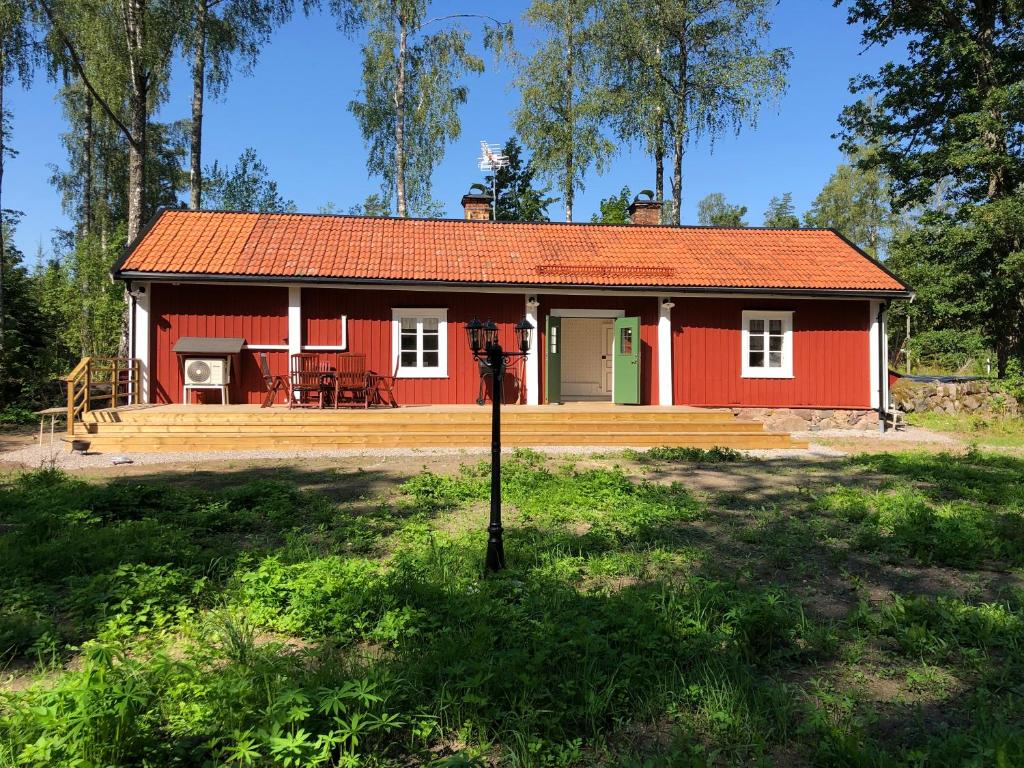 uma casa vermelha no meio de um campo em Nedanby | Cottage | Idyllic location | Porch | Grill em Edsbro