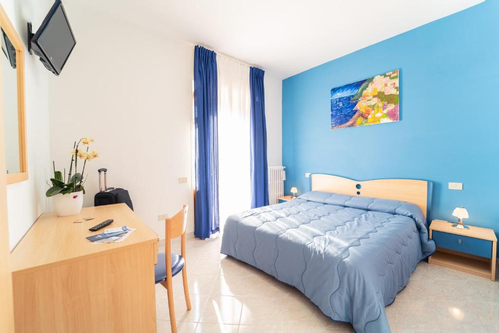a blue bedroom with a bed and a desk at Tra I Monti in Tramonti