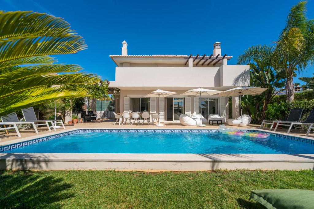 a villa with a swimming pool in front of a house at Casa Eleonora lifestyle Lodge in Lagos