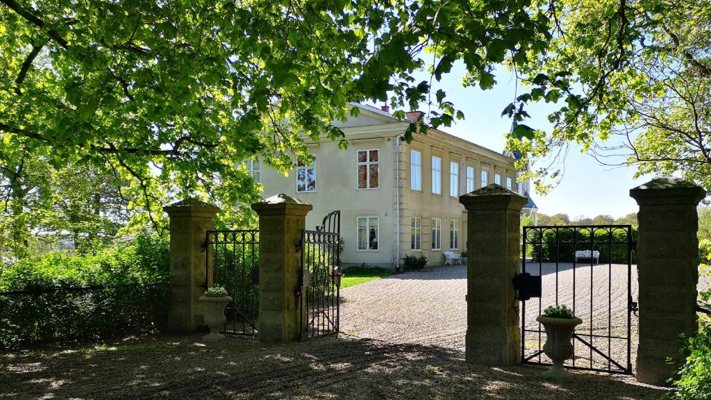 a gate in front of a white house at Hoby Gård B&B in Bräkne-Hoby