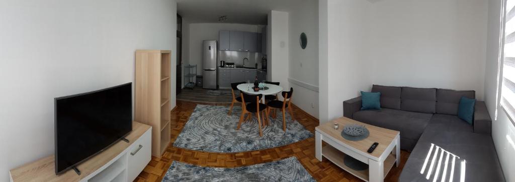 een woonkamer met een bank en een flatscreen-tv bij Apartment Emina in Travnik