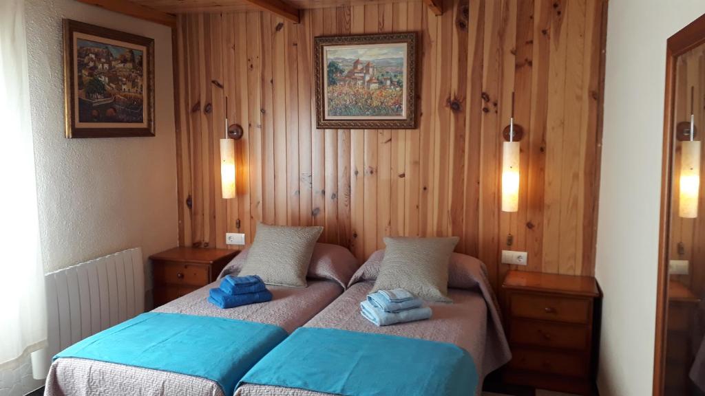 1 dormitorio con 2 camas y toallas azules. en Montblanc Medieval, Ruta del Cister, Costa Dorada, en Montblanc