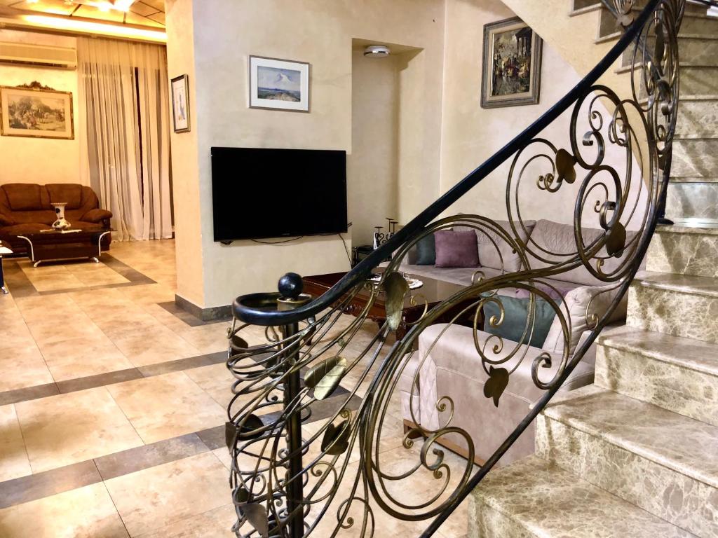 a spiral staircase in a living room with a television at Luxury City Center Tumanyan street Apartment in Yerevan