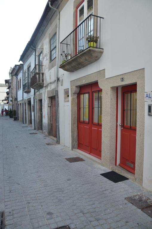 a row of buildings with red doors on a street at Jenny and Carmie TOWN HOUSE in Viana do Castelo