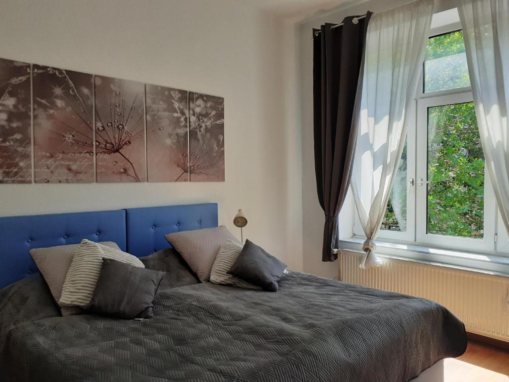 sypialnia z niebieskim łóżkiem i oknem w obiekcie Liberty w mieście Wilhelmshaven