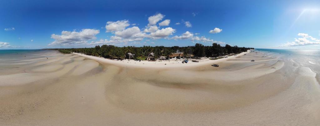 a view of a sandy beach with trees in the distance at Vilancool Beach Resort in Vilanculos