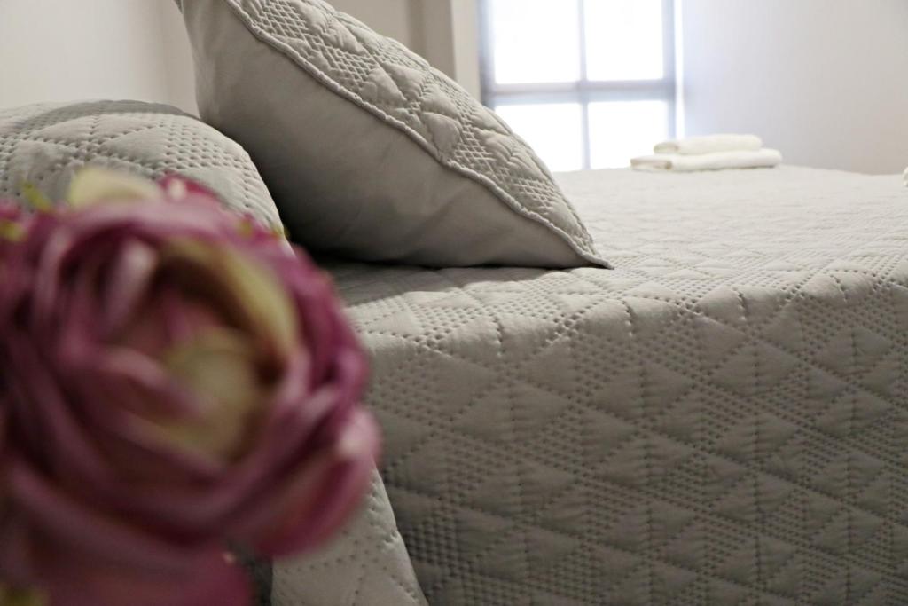 1 cama blanca con almohadas en Apartamentos Credencial, en Sarria