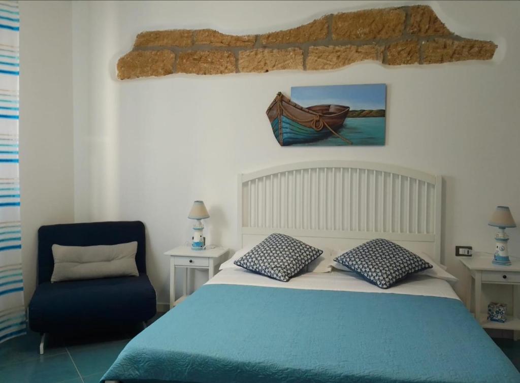 1 dormitorio con 1 cama y 1 silla azul en Ca&Sa Sweet Holiday en Cinisi