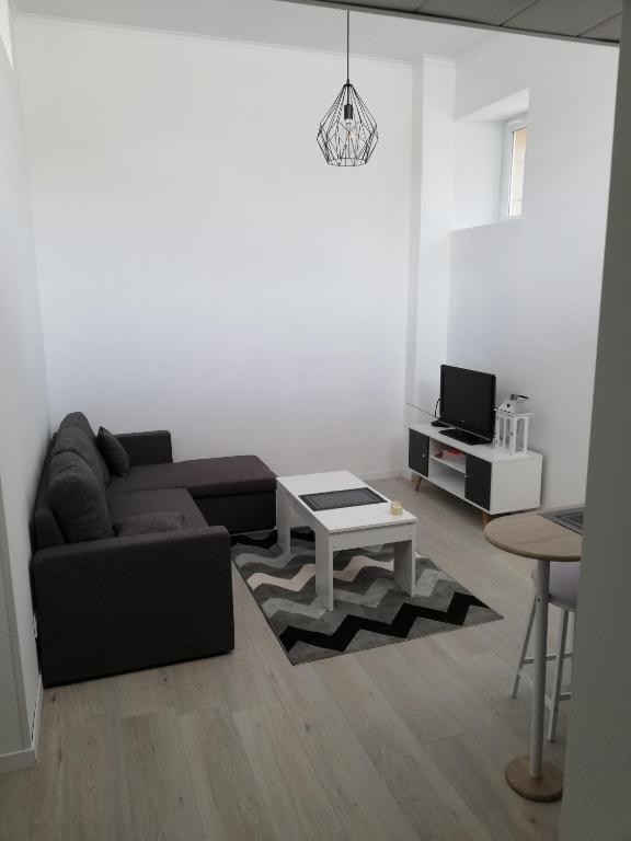 un salon avec un canapé et une table dans l'établissement Le Duplex reseau Cycle gites, à Fleury-sur-Orne