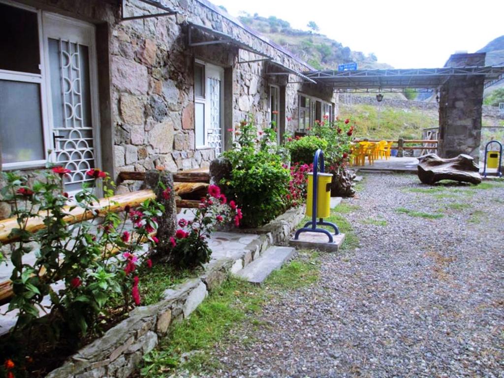 ein Steinhaus mit Blumen draußen in der Unterkunft SADA Guesthouse in Wardsia