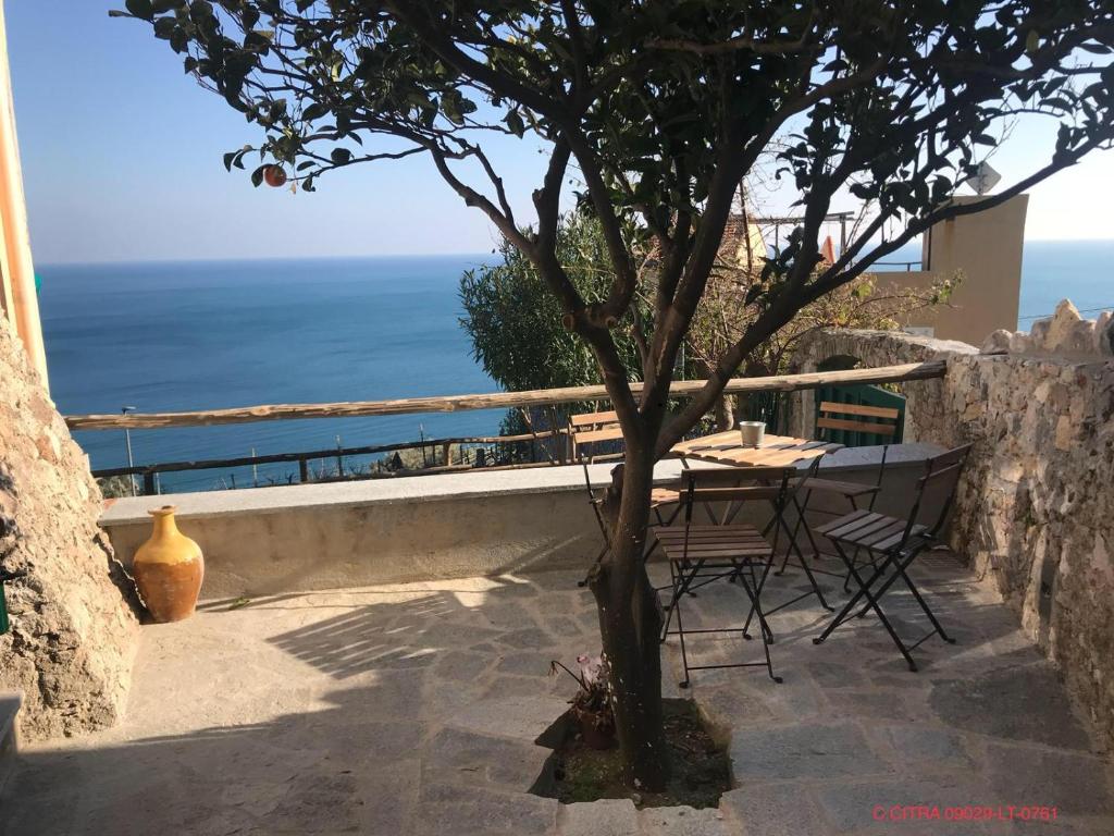 einen Tisch und Stühle auf einer Terrasse mit Meerblick in der Unterkunft Sant’Antonio in Finale Ligure