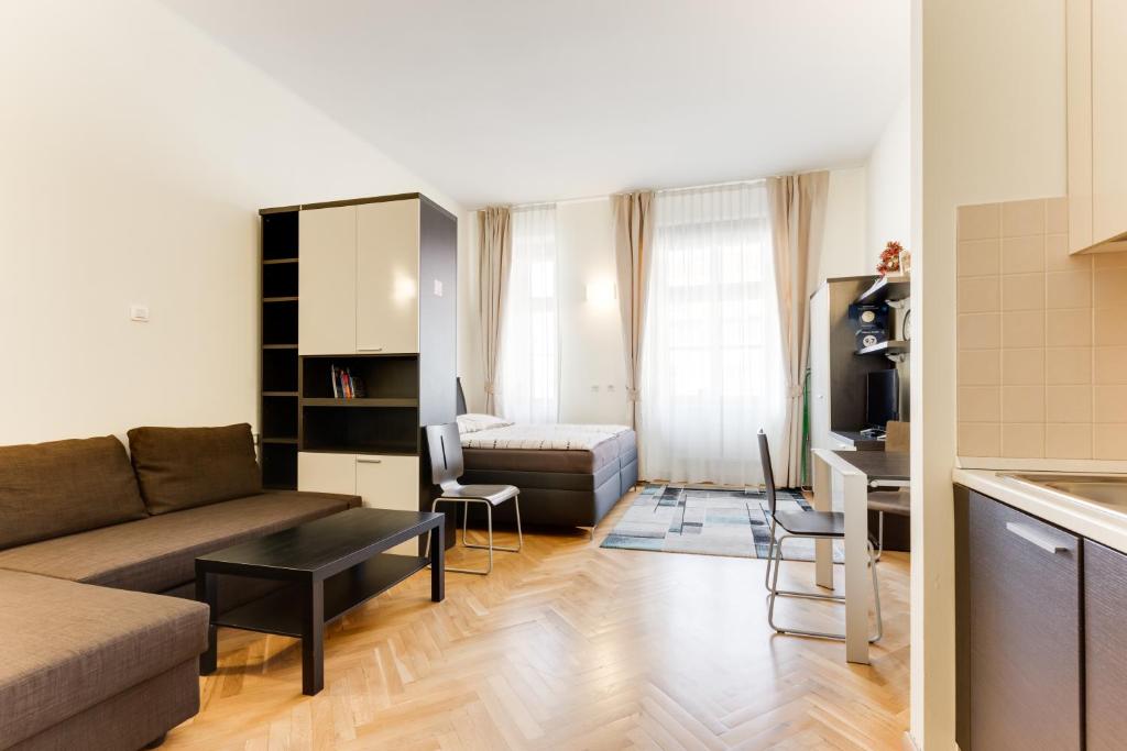 ein Wohnzimmer mit einem Sofa und einem Tisch in der Unterkunft Hálkova Studio in Prag