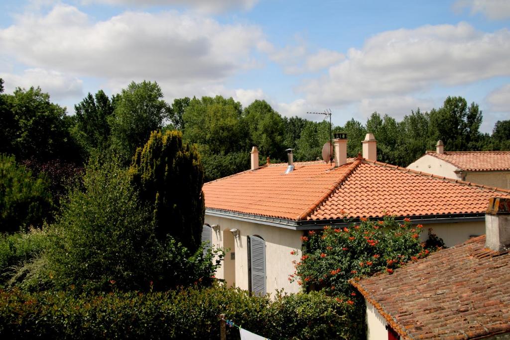 een wit huis met een oranje tegeldak bij Maison d'hôtes LE LAVOIR in Fontaines