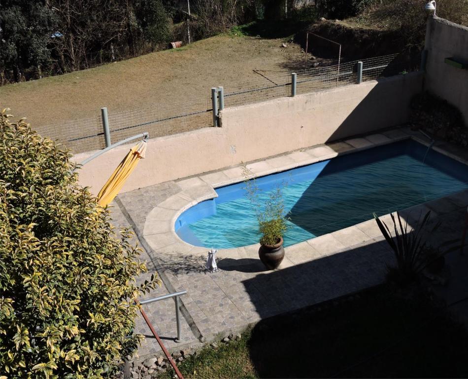 una piscina con una maceta al lado en Luciana G en Río Ceballos