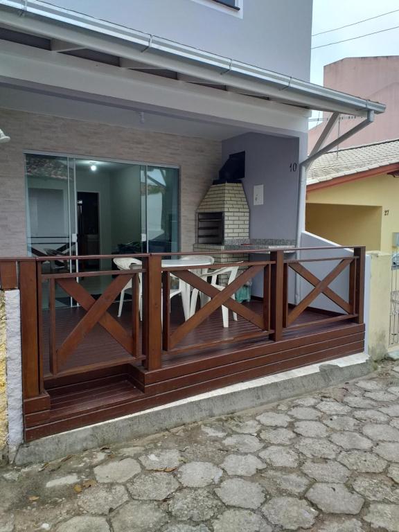 eine Holzterrasse mit einem Esstisch auf einem Haus in der Unterkunft Casa de Veraneio in Governador Celso Ramos