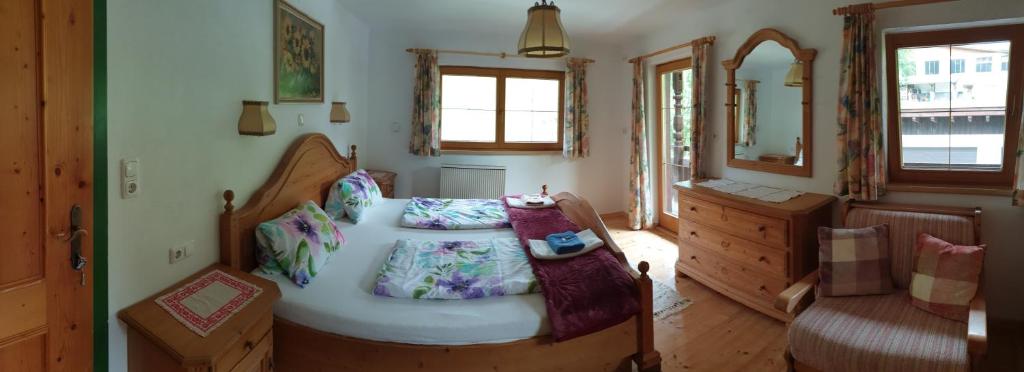 sypialnia z łóżkiem, komodą i lustrem w obiekcie Ferienhaus Ewerk w Alpbach