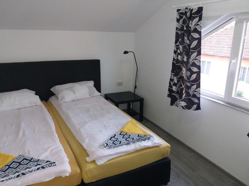 sypialnia z 2 łóżkami i oknem w obiekcie CASA BARZA w mieście Orăştie