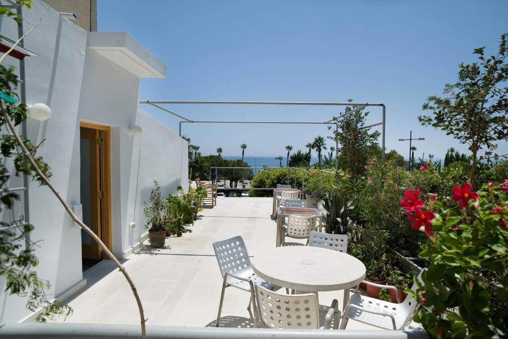 un patio con mesa, sillas y flores en City Centre Rooms, en Limassol