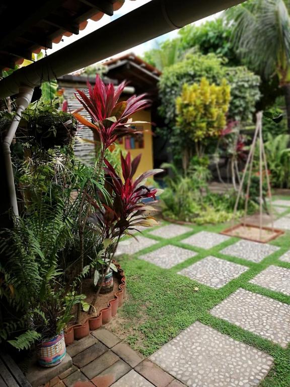 a garden with plants and a stone walkway at Pousada do farol in Jericoacoara