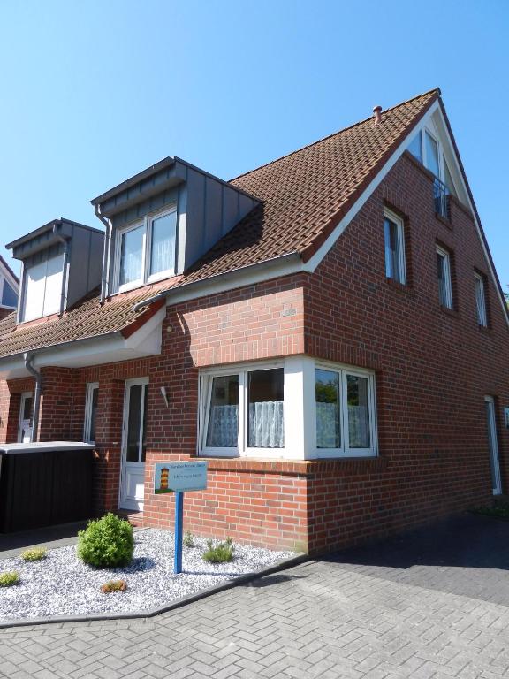 a red brick house with a sign in front of it at Nordseesonne Greetsiel in Krummhörn