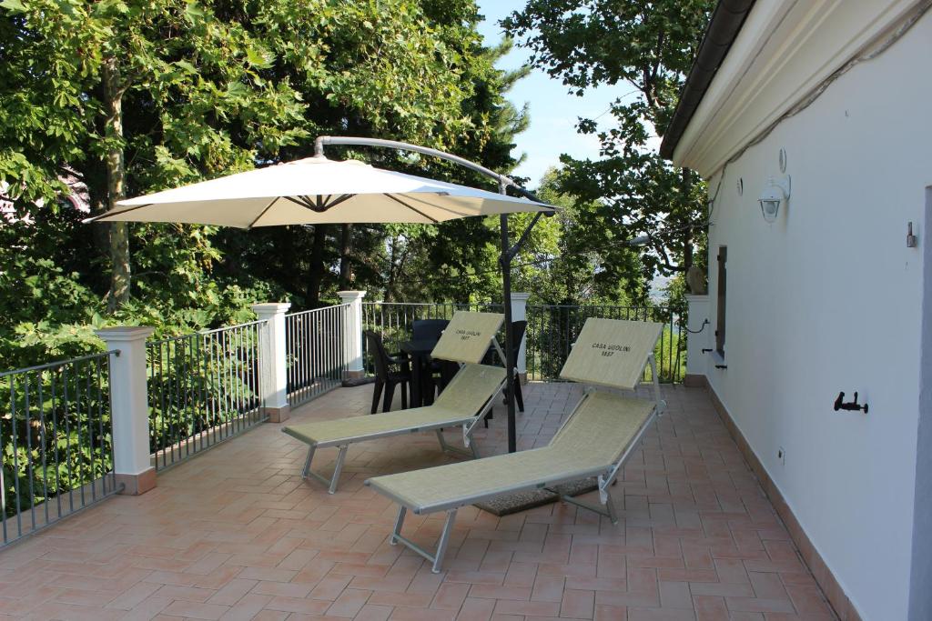 a patio with a table and an umbrella and chairs at Casa Ugolini since 1857 in Montescudo