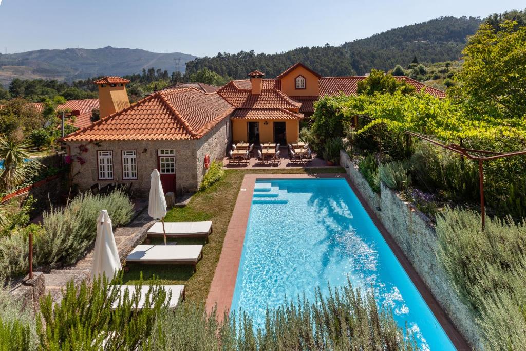 a house with a swimming pool in front of a house at Casa do Eido - sustainable living & nature experiences in Valdosende