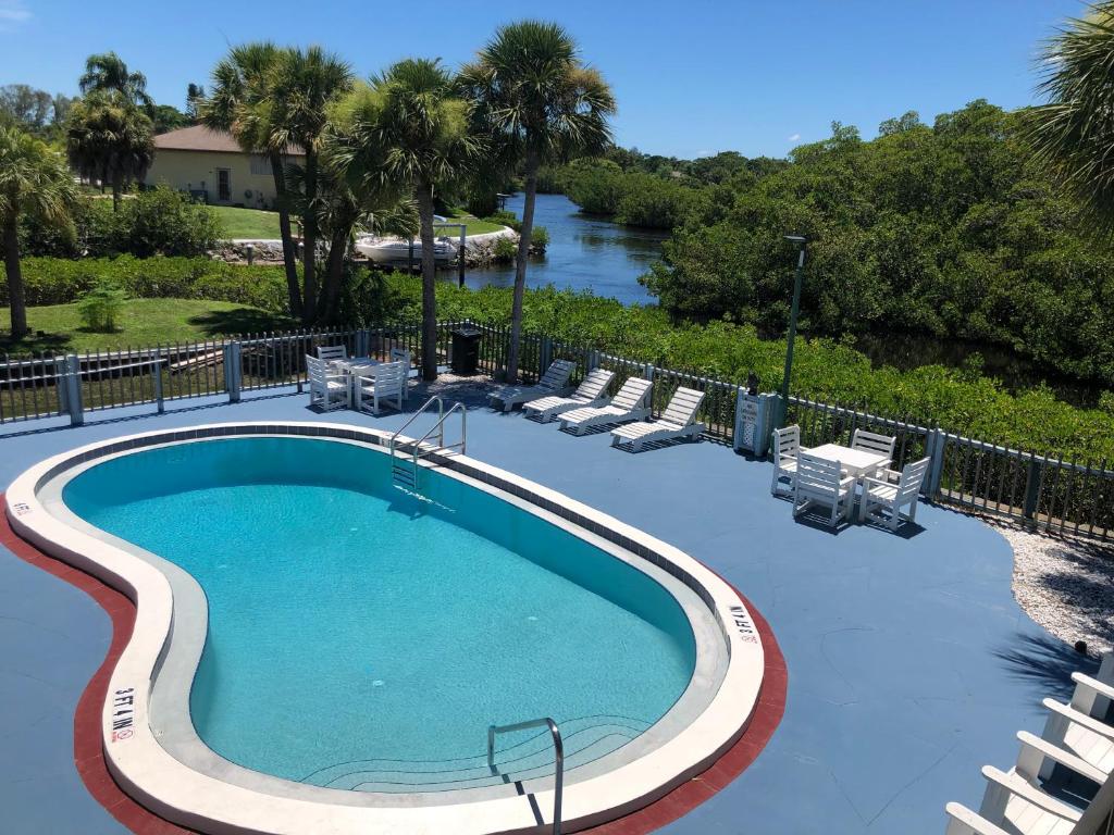 una gran piscina con sillas y un río en Sun Coast Inn, en Englewood