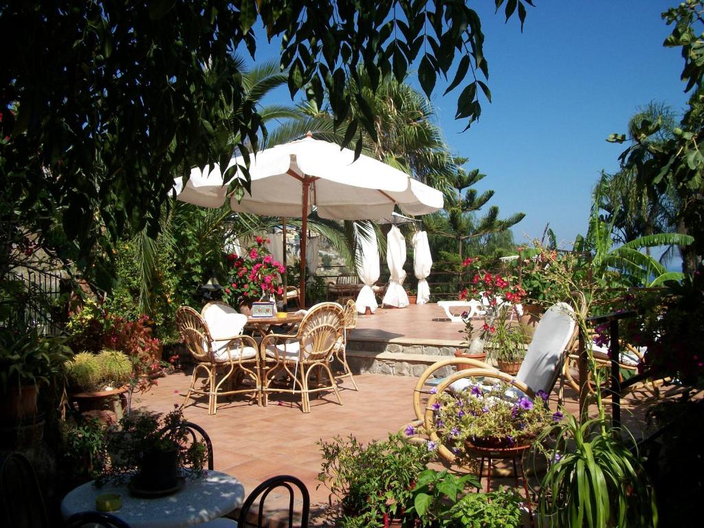 patio con tavolo, sedie e ombrellone di holidaysora Taormina - il giardino di Graziella a Taormina