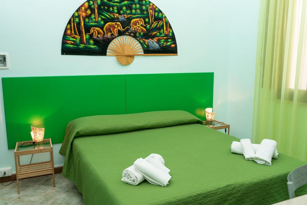 a green bedroom with a green bed with towels on it at B&B Favignana in Favignana